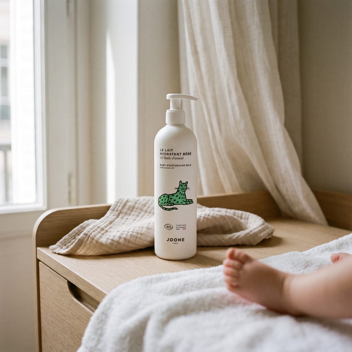 joone paris lait hydratant bébé op een commode naast een babyvoetje